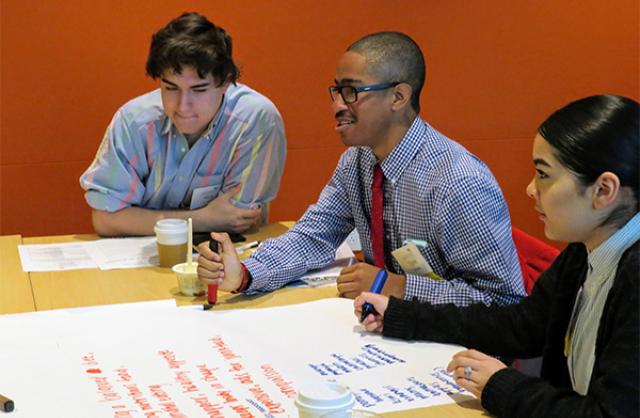 Three teens at desk working together